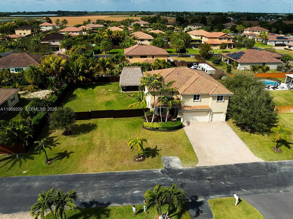 Aerial photograph of a two-story tile-roof home on a landscaped lot